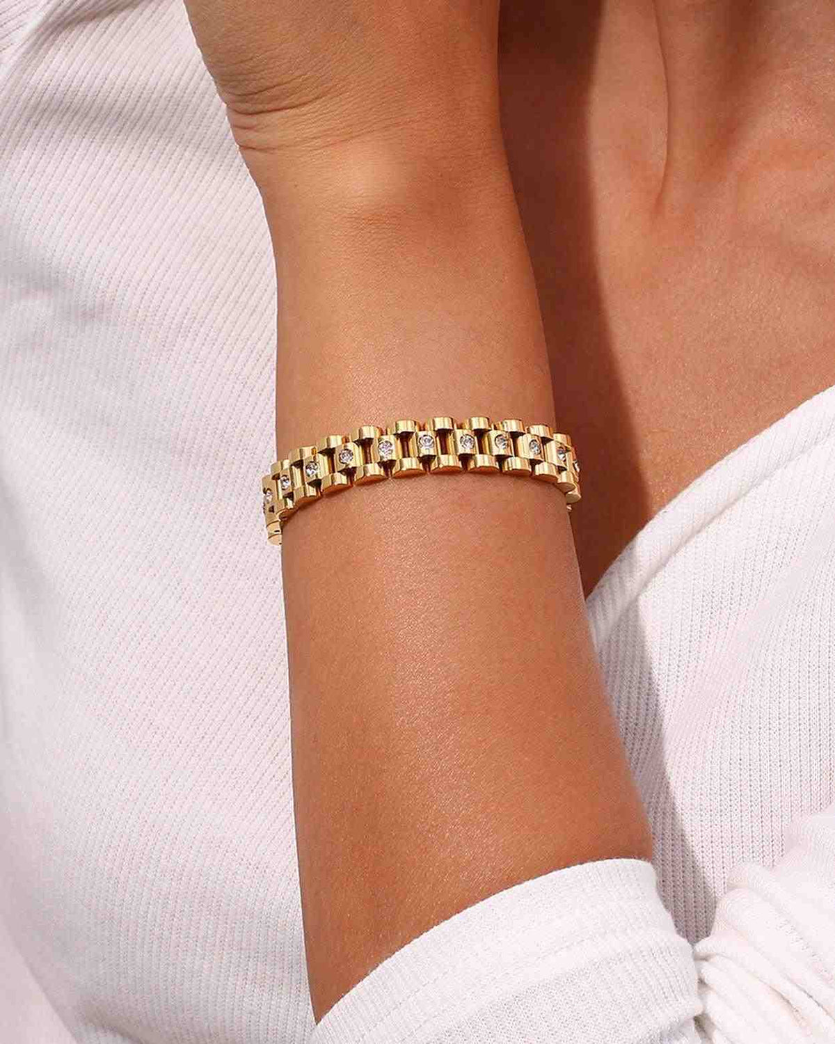 Closeup of a woman's hand wearing 18k Gold Plated Micro Zircon Studded Michael Bold Watchband Bracelet.